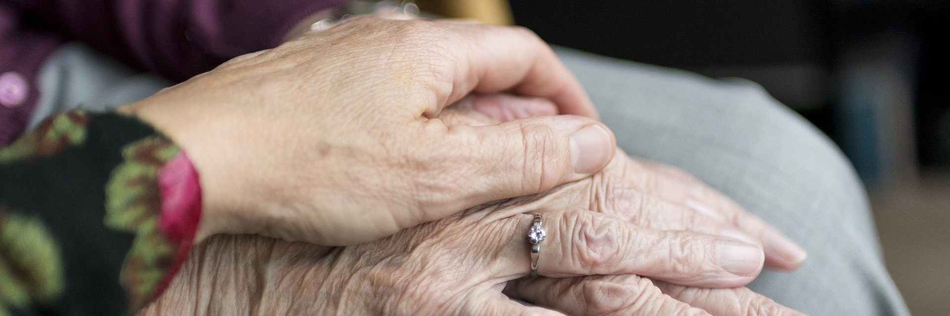 Photographie montrant deux mains, l'une d'une personne âgée et l'autre d'une personne plus jeune, l'une sur l'autre